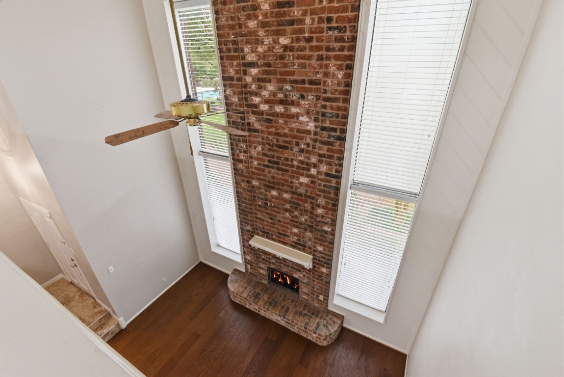 727 Bunker Hill Road, Unit 34 Houston, TX 77024 - Photo 33 of 50 Dramatic staircase with soaring brick wall and hardwood floors leading to the upper level