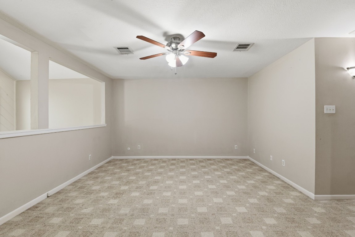 727 Bunker Hill Road, Unit 34 Houston, TX 77024 - Photo 36 of 50 Open upstairs game room with ceiling fan and neutral carpet — endless possibilities