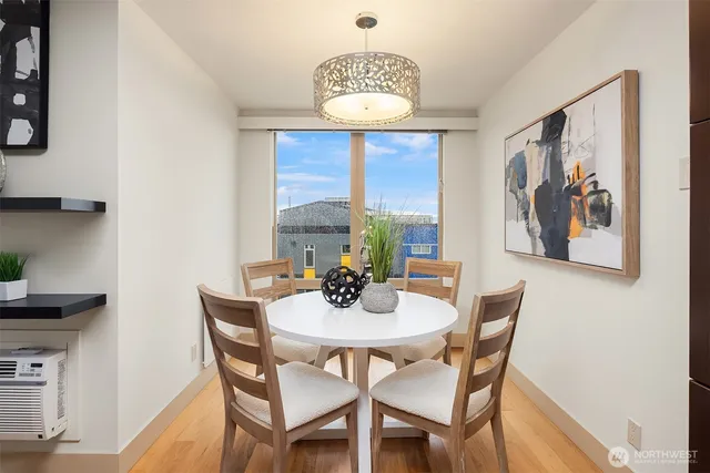 a living room with kitchen appliances furniture and a wooden floor