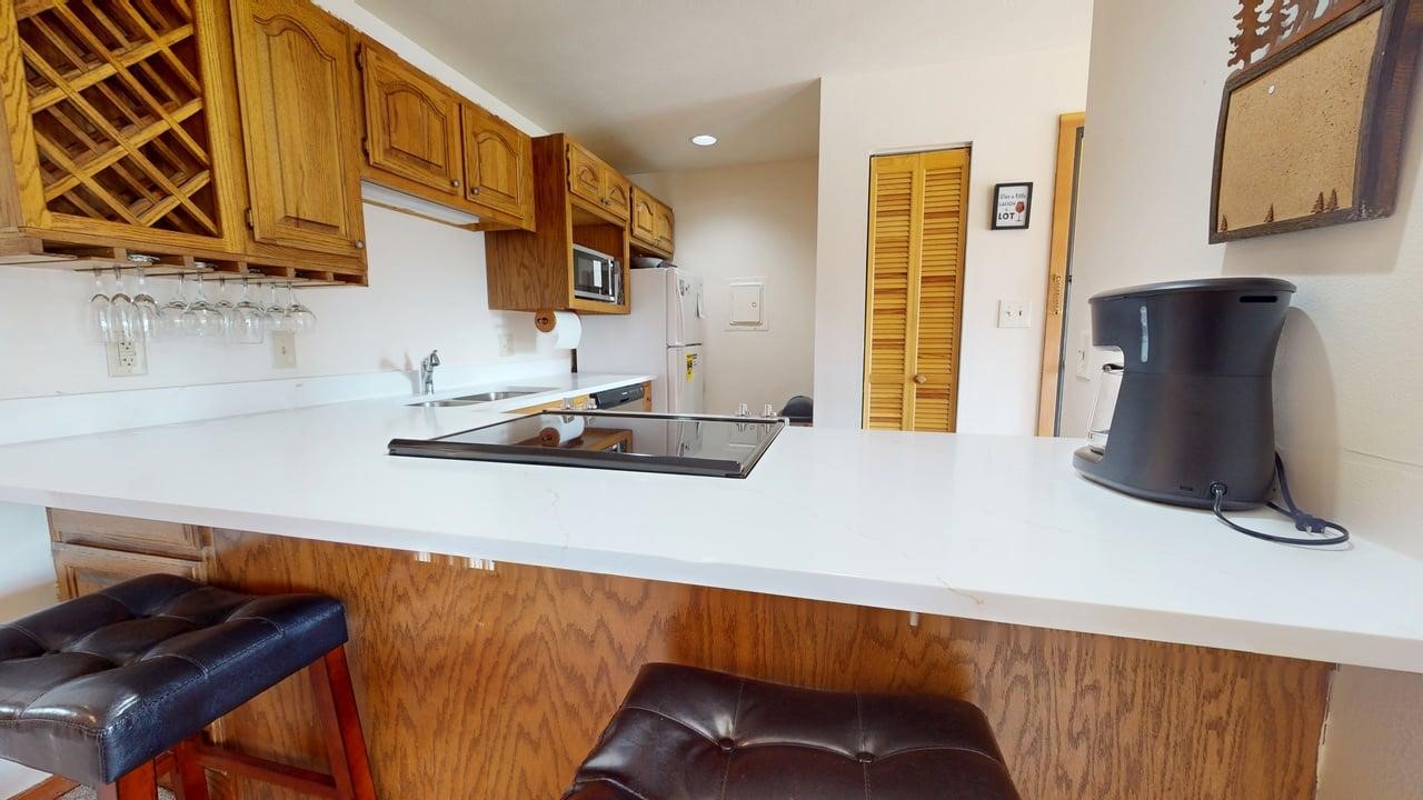 91200 Ryan Gulch Road, Unit 213 Silverthorne, CO 80498 - Photo 10 of 33 a kitchen with stainless steel appliances a sink a stove and a refrigerator