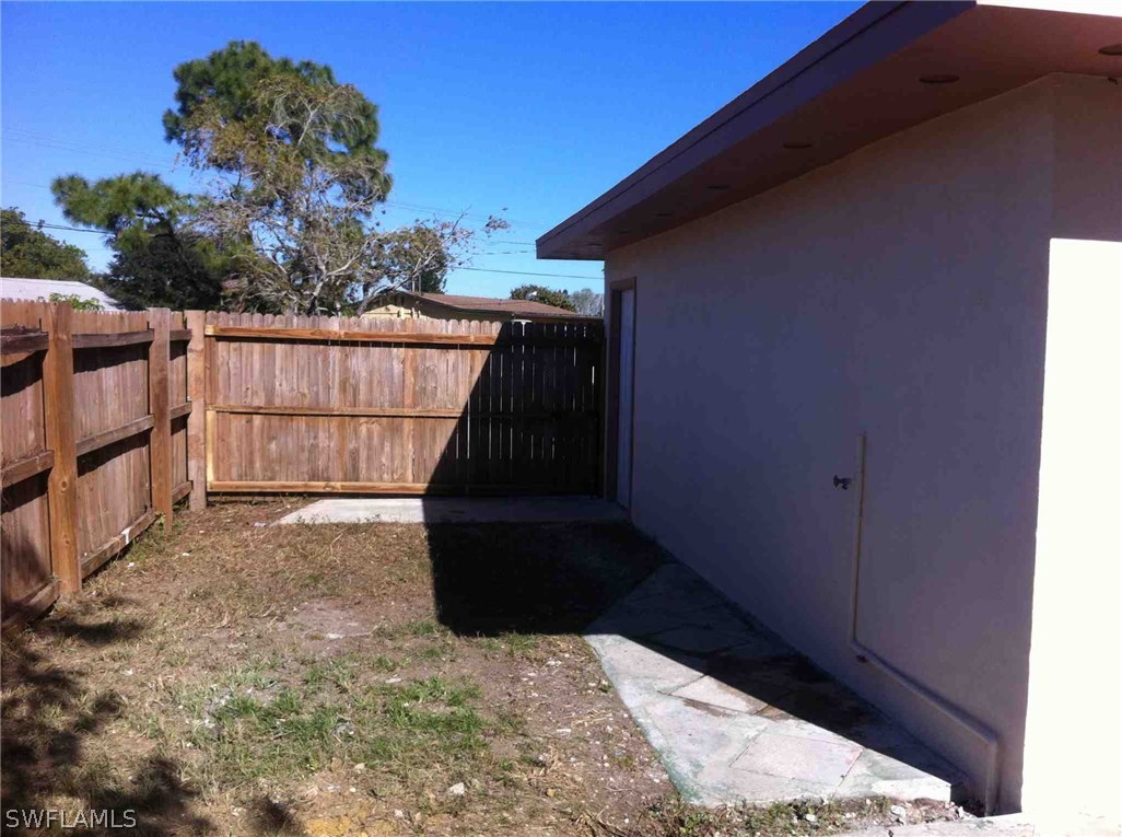 17 Iowa Road Lehigh Acres, FL 33936 - Photo 18 of 18 a view of backyard with wooden fence and trees