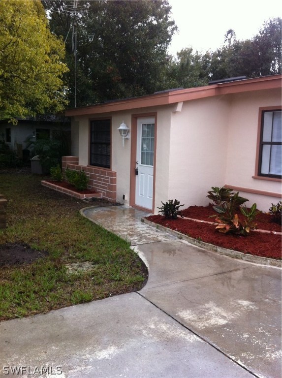 17 Iowa Road Lehigh Acres, FL 33936 - Photo 2 of 18 front view of a house with a patio
