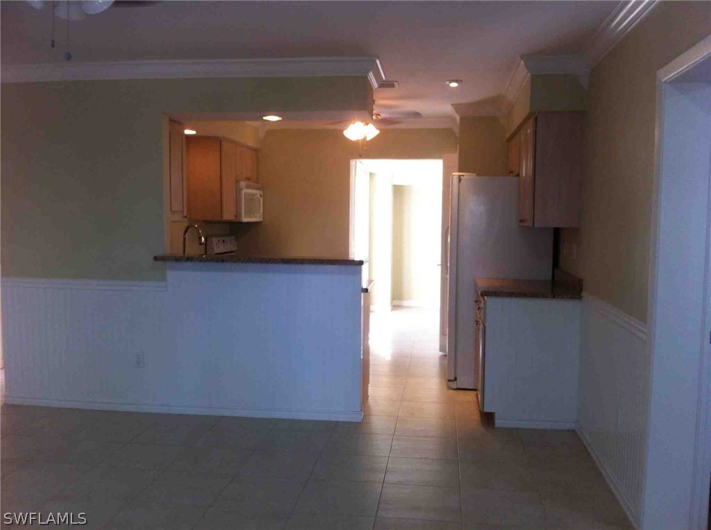 17 Iowa Road Lehigh Acres, FL 33936 - Photo 6 of 18 a view of a kitchen with a sink and a refrigerator