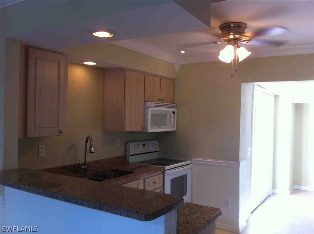 17 Iowa Road Lehigh Acres, FL 33936 - Photo 8 of 18 a kitchen with stainless steel appliances granite countertop a sink a stove and a microwave oven