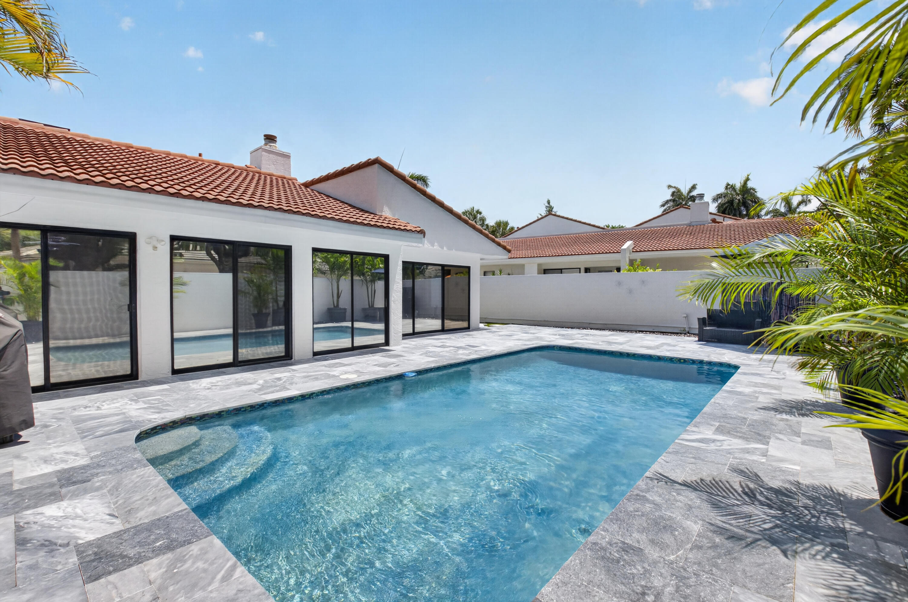 7374 Woodmont Court Boca Raton, FL 33434 - Photo 37 of 95 a front view of a house with a garden and yard