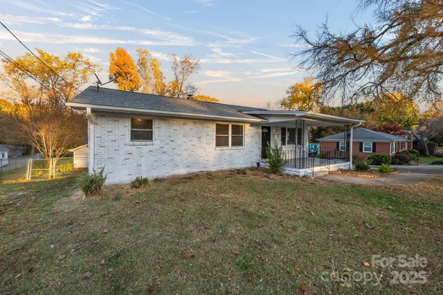 a view of a yard in front of a house with large tree