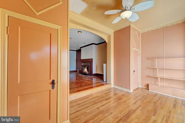 a view of a hallway with wooden floor and closet area