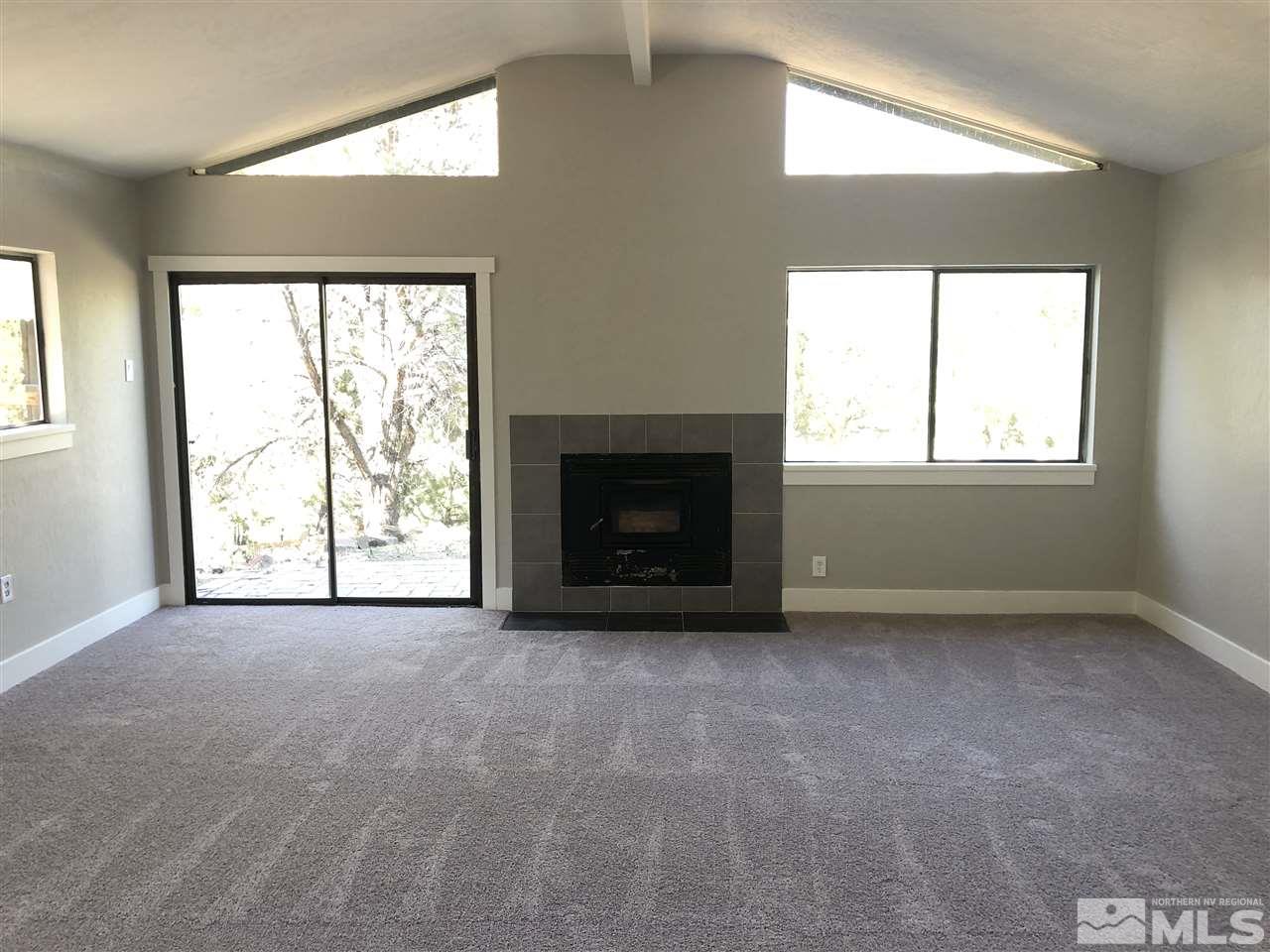 2421 Grizzley Road Reno, NV 89521 - Photo 8 of 13 an empty room with windows and fireplace