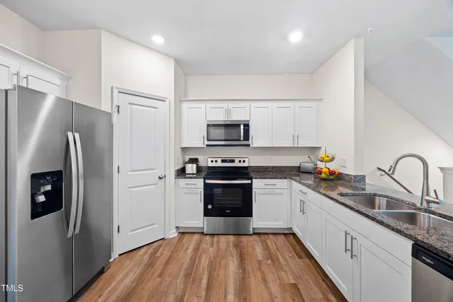 a kitchen with stainless steel appliances a refrigerator sink and microwave