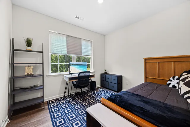 a bedroom with a bed and large windows