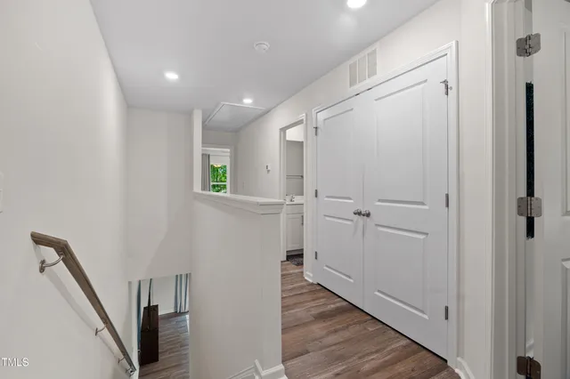 a view of a hallway with wooden floor and staircase