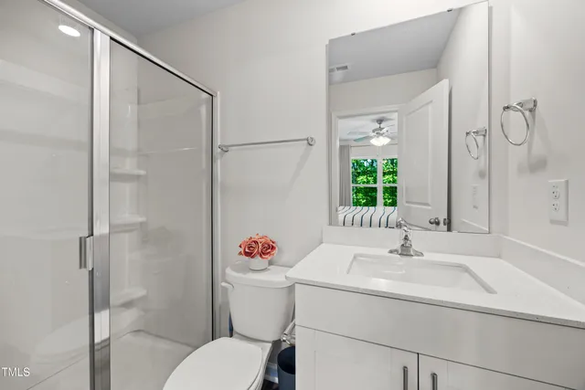 a bathroom with a sink vanity mirror and toilet