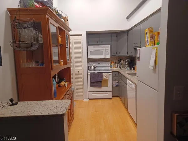 a kitchen with stainless steel appliances granite countertop a refrigerator a stove and a sink