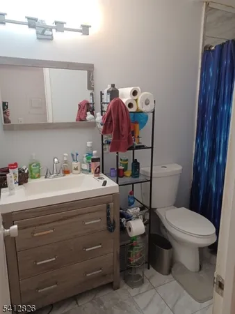 a bathroom with a toilet sink vanity and mirror