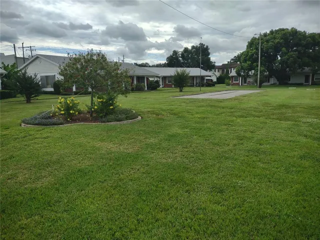a view of big yard with a house in the background
