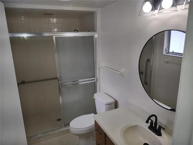a bathroom with a sink and mirror with toilet