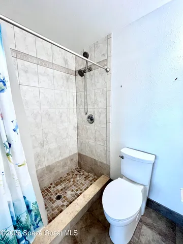 a bathroom with a toilet and a shower