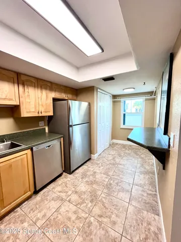 a kitchen with granite countertop a refrigerator and a sink