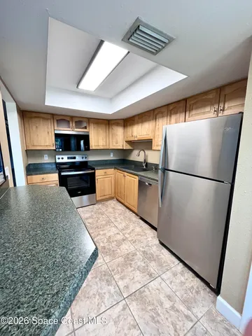 a kitchen with granite countertop a refrigerator and a sink