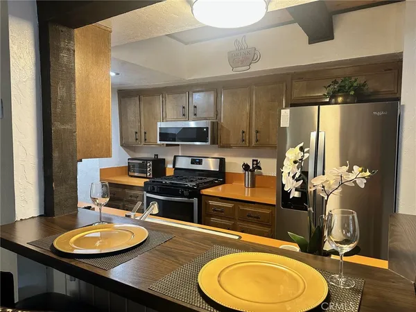 a kitchen with stainless steel appliances granite countertop a refrigerator and a stove