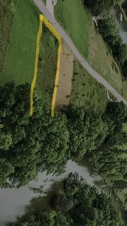 an aerial view of residential houses with outdoor space and trees