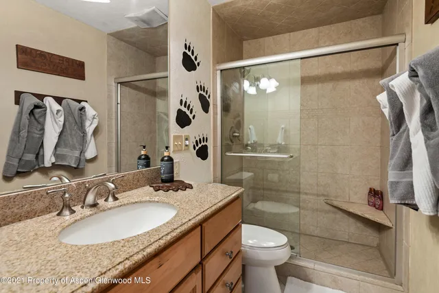 a bathroom with a granite countertop sink toilet and shower