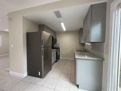 a bathroom with a granite countertop sink toilet and mirror