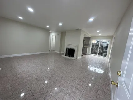a view of a big room with large windows and a kitchen