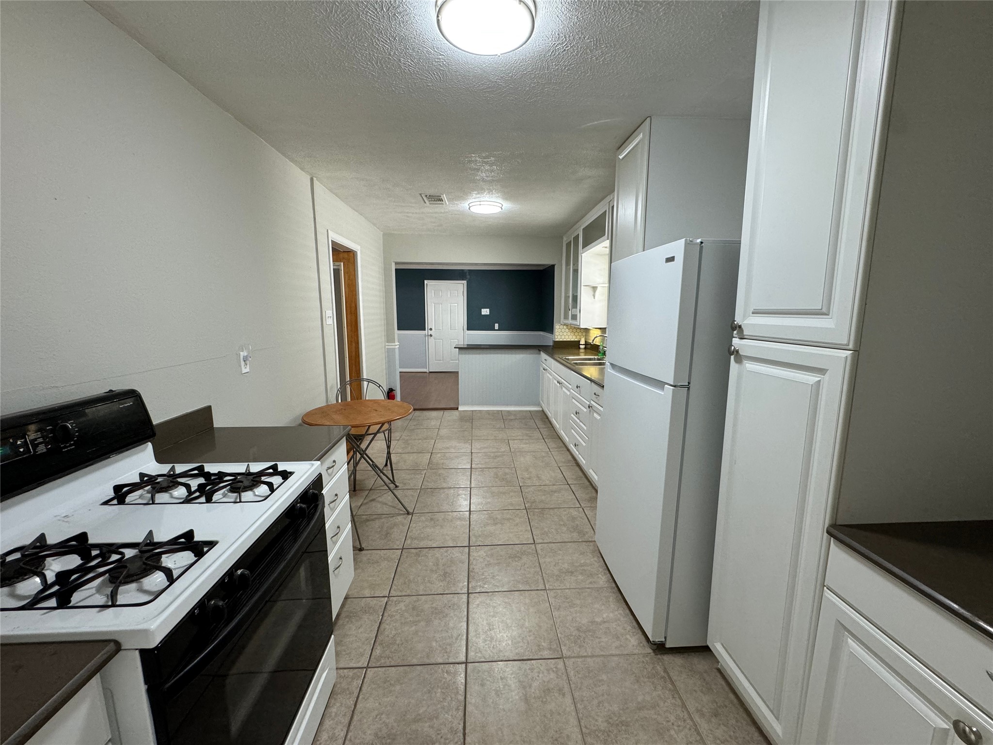 125 Pomeroy Street Pasadena, TX 77506 - Photo 11 of 19 a kitchen with a refrigerator and a stove top oven
