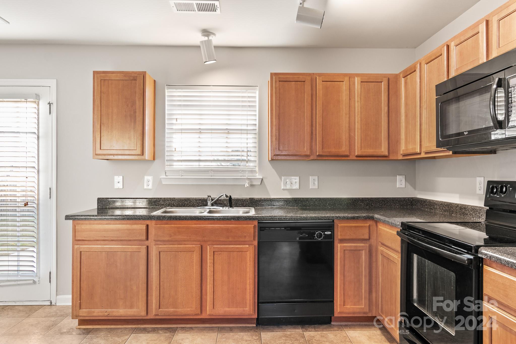 4071 Clover Road Northwest Concord, NC 28027 - Photo 23 of 43 a kitchen with granite countertop a stove top oven microwave and cabinets