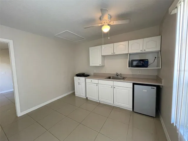 a kitchen with granite countertop white cabinets and white appliances