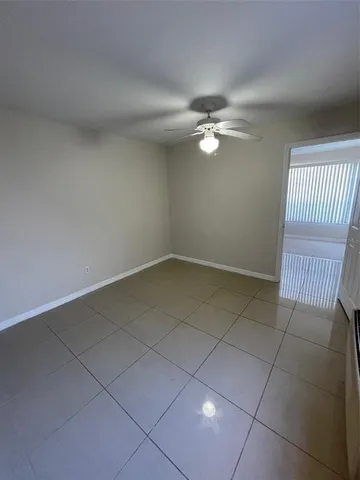an empty room with a ceiling fan and a window