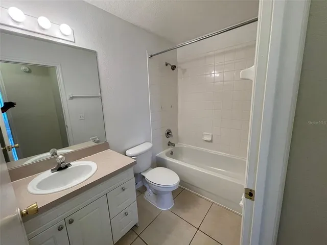 a bathroom with a sink a toilet a mirror a vanity and shower