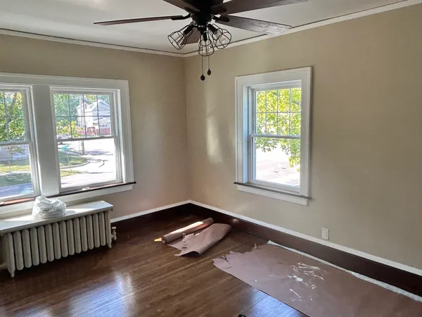 a living room with wooden floor and windows
