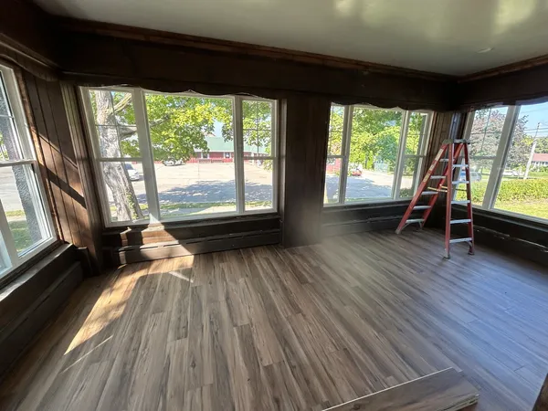 a view of a room with wooden floor and furniture