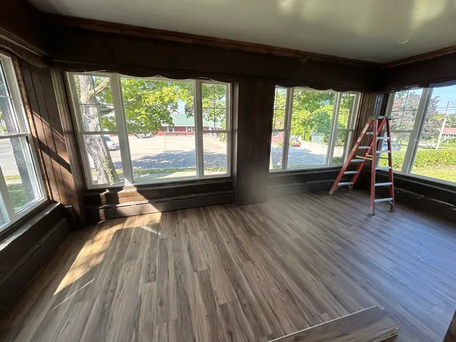 a view of a room with wooden floor and furniture