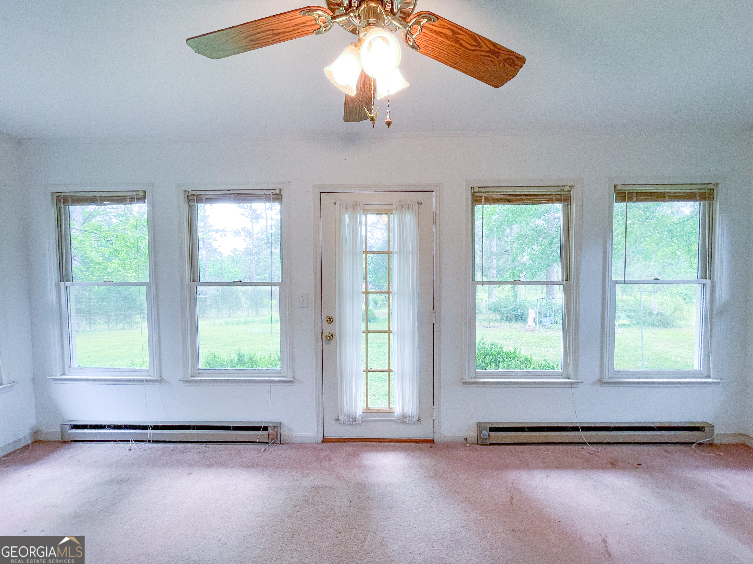 7517 Blacks Bluff Road Southwest Cave Spring, GA 30124 - Photo 30 of 57 an empty room with windows and chandelier fan