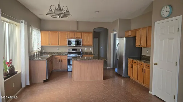 a kitchen with a refrigerator a stove cabinets and a dining table