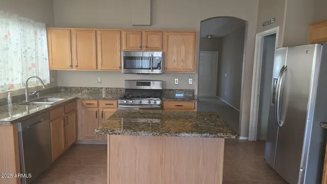 a kitchen with stainless steel appliances granite countertop a refrigerator a stove a sink and a granite counter tops