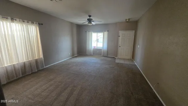 a view of a livingroom with a ceiling fan and window