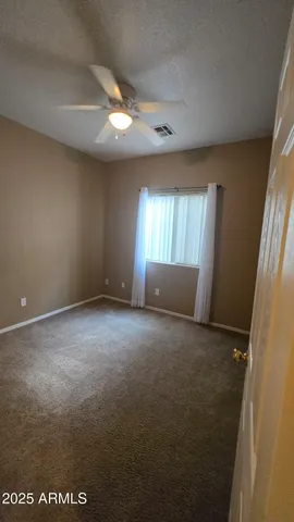 an empty room with windows and cabinet