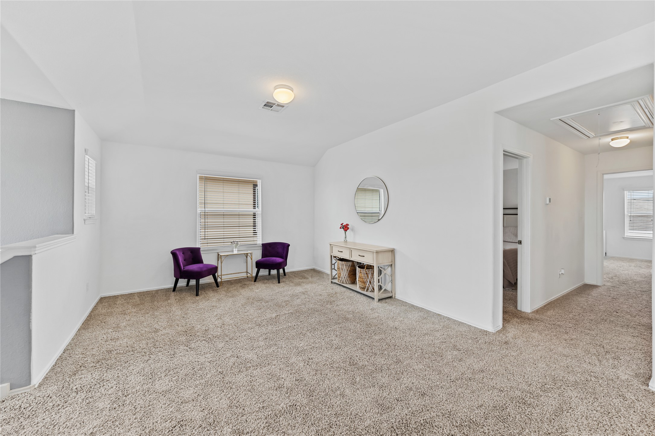 425 Perfect World Loop Jarrell, TX 76537 - Photo 15 of 29 Expansive carpeted loft area featuring white walls, a recessed window, and a hallway entry