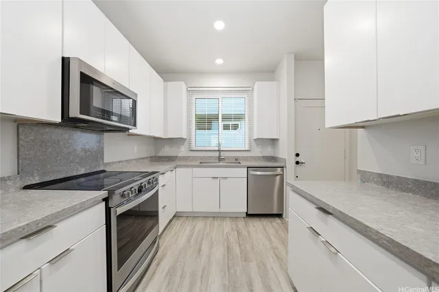 a kitchen with a stove a sink and a microwave