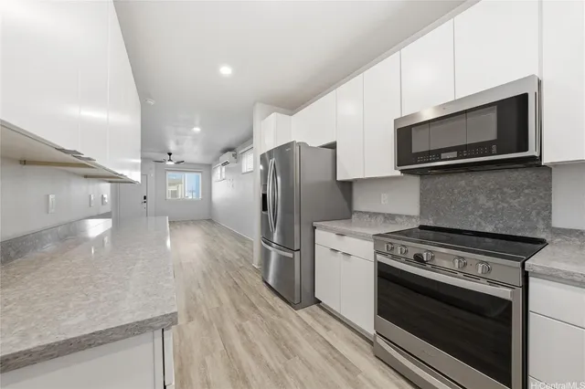 a kitchen with stainless steel appliances a stove a microwave and a hard wood floor