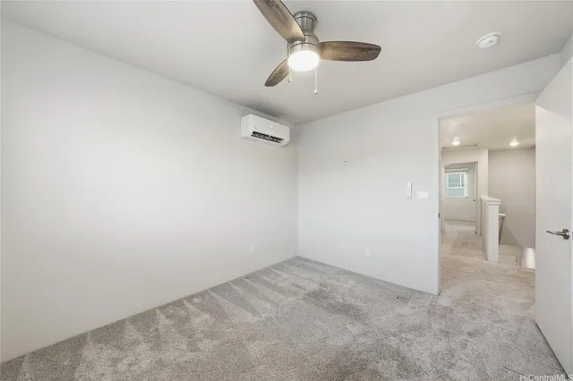 an empty room with a ceiling fan and bathroom view