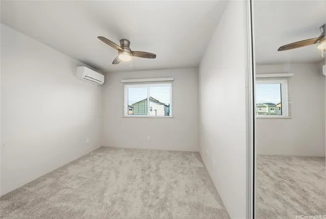 an empty room with a window and a ceiling fan