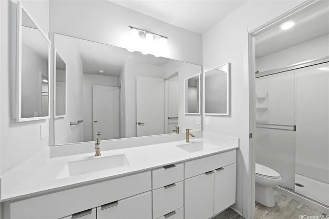 a bathroom with a sink double vanity granite and a toilet