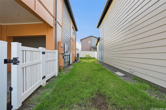 a view of a house with backyard and wooden fence