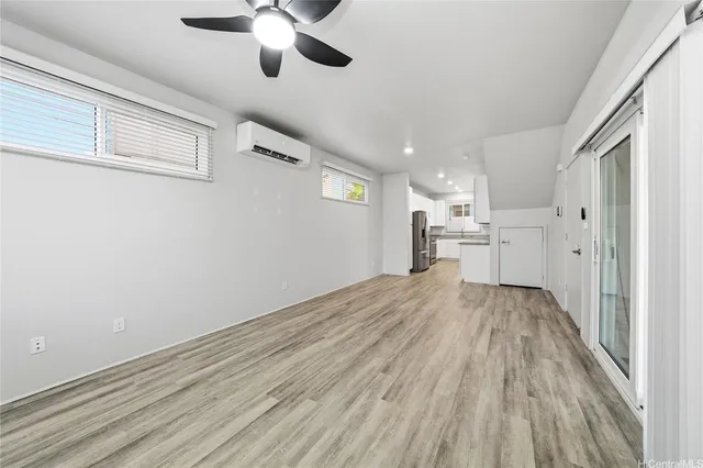 a view of empty room with wooden floor and window