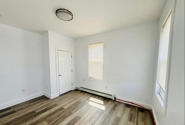 a view of a room with wooden floor and window